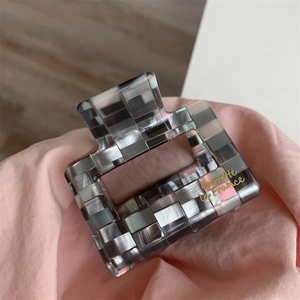 Détail de la pince à cheveux carrée à carreaux gris avec lettrage doré Barrette la France
