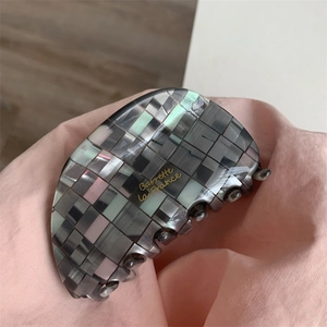 Détail de la pince à cheveux à carreaux avec l'inscription dorée Barrette La France