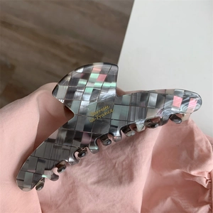 Détail d'une grande pince à cheveux en acétate avec motif mosaïque gris et nacré
