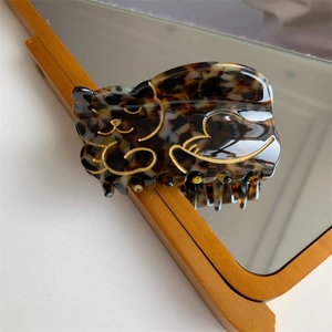 Detail of tortoise shell acetate cat hair claw clip showing glossy finish and gold accents