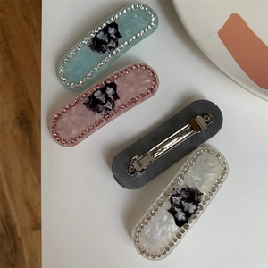 Three rhinestone cat hair clips in mint green, pink, and white marble acetate