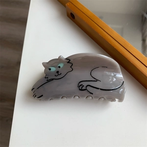 Detailed view of gray marble acetate cat hair claw clip with blue eyes on white surface