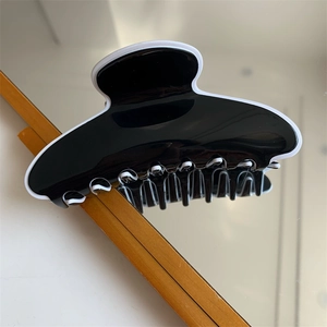 Détail d'une pince à cheveux minimaliste noire et blanche avec finition brillante