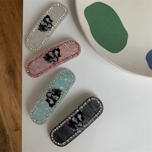 Detail view of cat pattern hair clips with sparkling rhinestones and marble texture