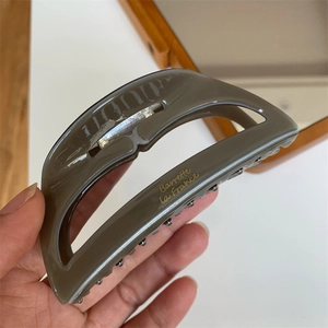 Detail view of large acetate hair claw clip with golden Barrette La France lettering