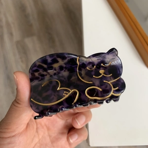 Detail of a purple leopard print cat claw clip made from premium acetate with gold lines