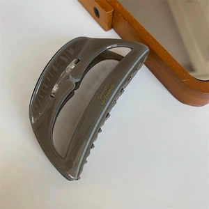 Detail of grey acetate hair claw clip with gold Barrette la France lettering