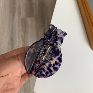 Detail of purple and beige marbled acetate hair claw clip with silver metal spring