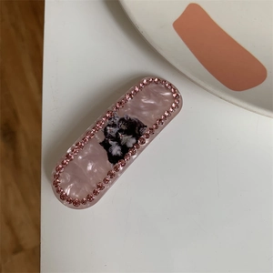 Detail of pink marble acetate hair clip with rhinestones and cute cat patterns