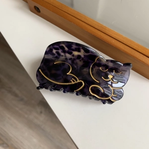 Detailed view of an orange and black tortoiseshell cat hair claw clip for high ponytails
