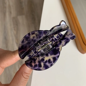 Detail of purple tortoiseshell hair claw clip with transparent finish and metal spring