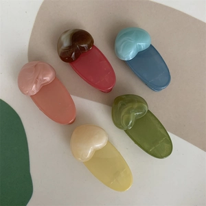 Set of five colorful jelly heart hair clips with marble texture on a neutral background