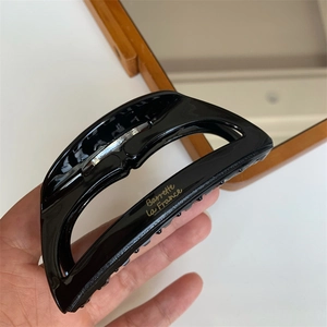 Detail of black acetate shark clip with golden Barrette La France lettering