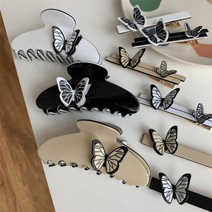 Detail of French vintage butterfly hair clips in pearl white and black glossy finish