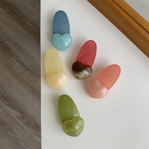 Close-up of heart-shaped jelly hair clips in five colors with marble texture resin