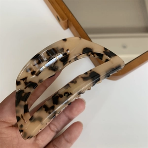 Detail showing tortoise shell acetate hair claw clip with golden Barrette La France text