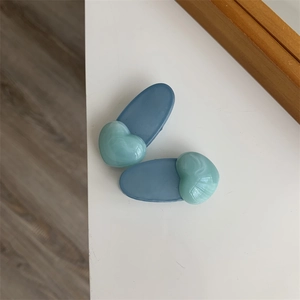 Detail view of heart-shaped jelly hair clips with green marble texture and blue base
