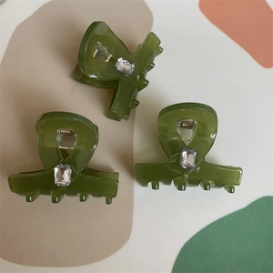 Detailed view of olive green hair claws with square crystal accents in a 3-piece set