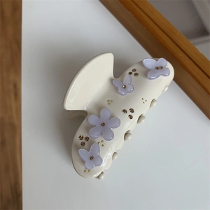 Dettaglio della molletta color crema con farfalle viola e strass ambrati