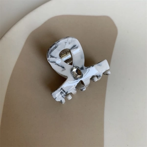 Detail view of the black and white marble hair claw clip with a square sparkling rhinestone
