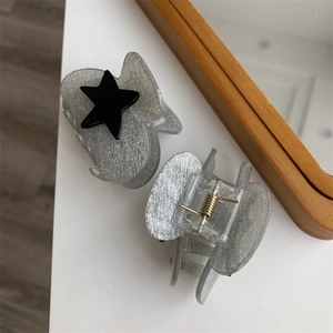 Close-up of grey glitter star hair claw clips with detailed view of spring mechanism