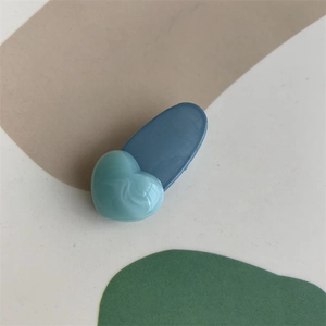 Detailed macro view of the marble texture on a blue heart-shaped hair clip with resin finish