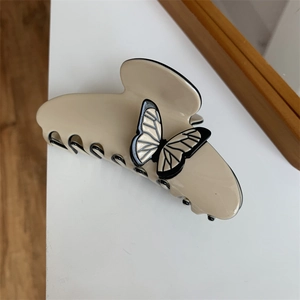 Close-up of a beige butterfly hair claw with black texture and polished resin finish