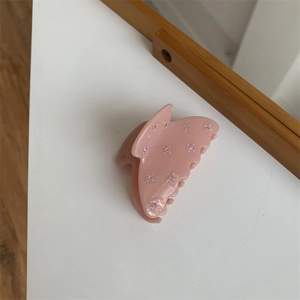 Vue détaillée d'une pince à cheveux rose avec strass en étoile et mécanisme à ressort