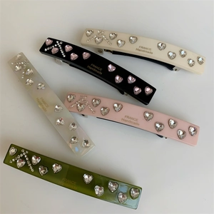 Detailed view of colorful handmade resin barrettes with crystal heart patterns