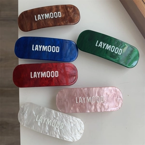 Lot de six barrettes à cheveux effet marbre avec logo Laymood en couleurs variées sur table