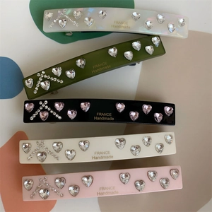 Detailed macro view of high-quality resin hair clips with sparkling heart rhinestones