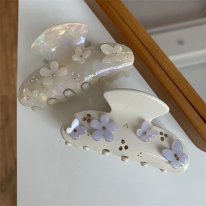 Dettaglio delle pinze per capelli con fiori decorativi, farfalle e cristalli incastonati