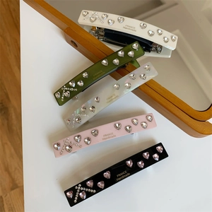 Close-up of handmade spring hair clips with heart rhinestones and cross patterns