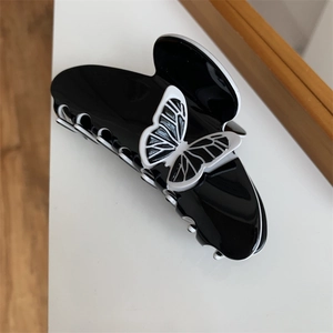 Detail view of a vintage butterfly hair clip in polished black and white acrylic finish