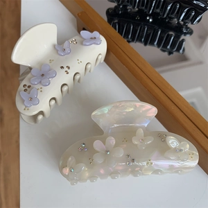 Dettaglio dei fermagli per capelli a farfalla con finitura opaca e fiori con strass