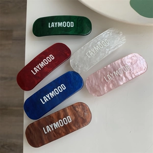 Gros plan de barrettes géométriques en acétate en six couleurs avec texture marbrée