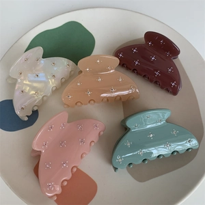 Lot de cinq pinces à cheveux élégantes avec strass en diverses couleurs pastel sur plateau