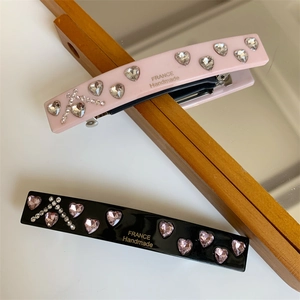 Detailed macro of handmade spring hair clips with heart crystals and France lettering