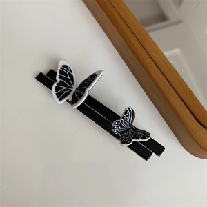 Detail of elegant butterfly hair clip with fine wing textures on a sleek black base