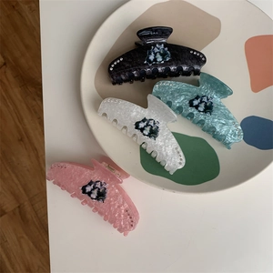 Close-up of cat pattern hair claws with rhinestones in black, cyan, white and pink