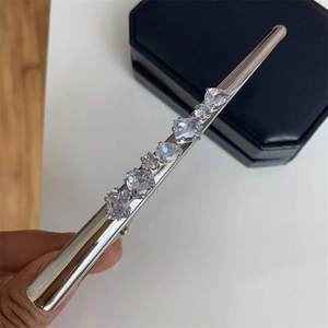 Détail d'une pince à cheveux argentée sertie de zircons de formes variées et chic