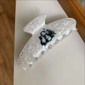 Close-up of pearl white hair claw clip with cat design and sparkling crystal inlay