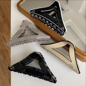 Detailed view of geometric triangle hair claws with rhinestones in four colors