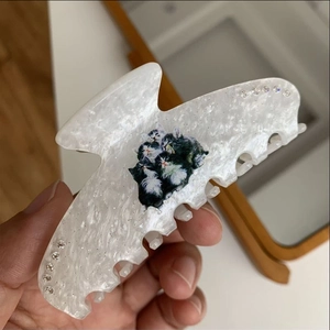 Detail of white pearl acetate hair claw with cat print and sparkling rhinestones
