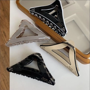 Detail of geometric triangle hair claws with rhinestones and acetate marble textures
