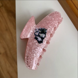 Close-up of pink glitter acrylic cat hair claw clip with rhinestones and cute print