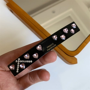 Detail showing pink crystal heart embellishments and gold France Handmade logo on hair clip