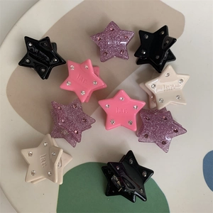Detailed close-up of mini star-shaped hair clips with rhinestones in diverse colors
