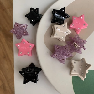 Macro shot of mini star hair clips with colorful glitter and small inlaid diamonds