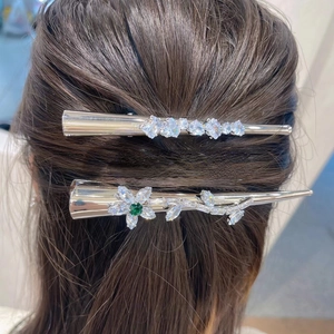 Barrettes élégantes argentées avec zircons blancs et verts sur cheveux foncés